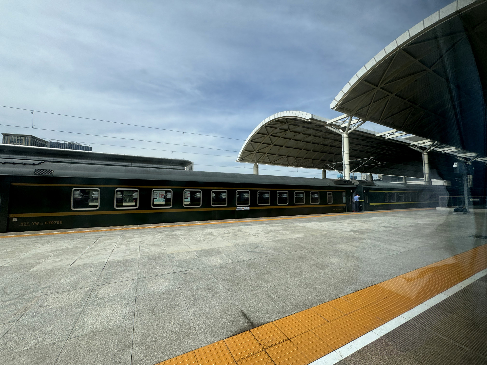 A green long-distance train at a platform in Xining Railway Station
