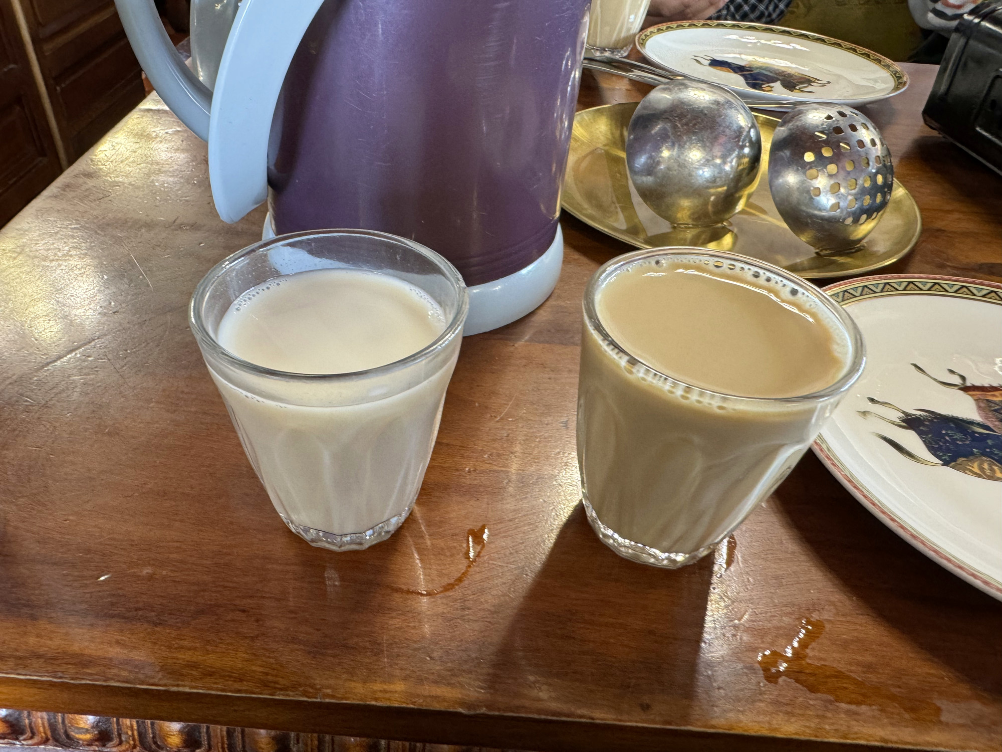 Two cups of Lhasa sweet tea and a hot-water flask on a wooden table