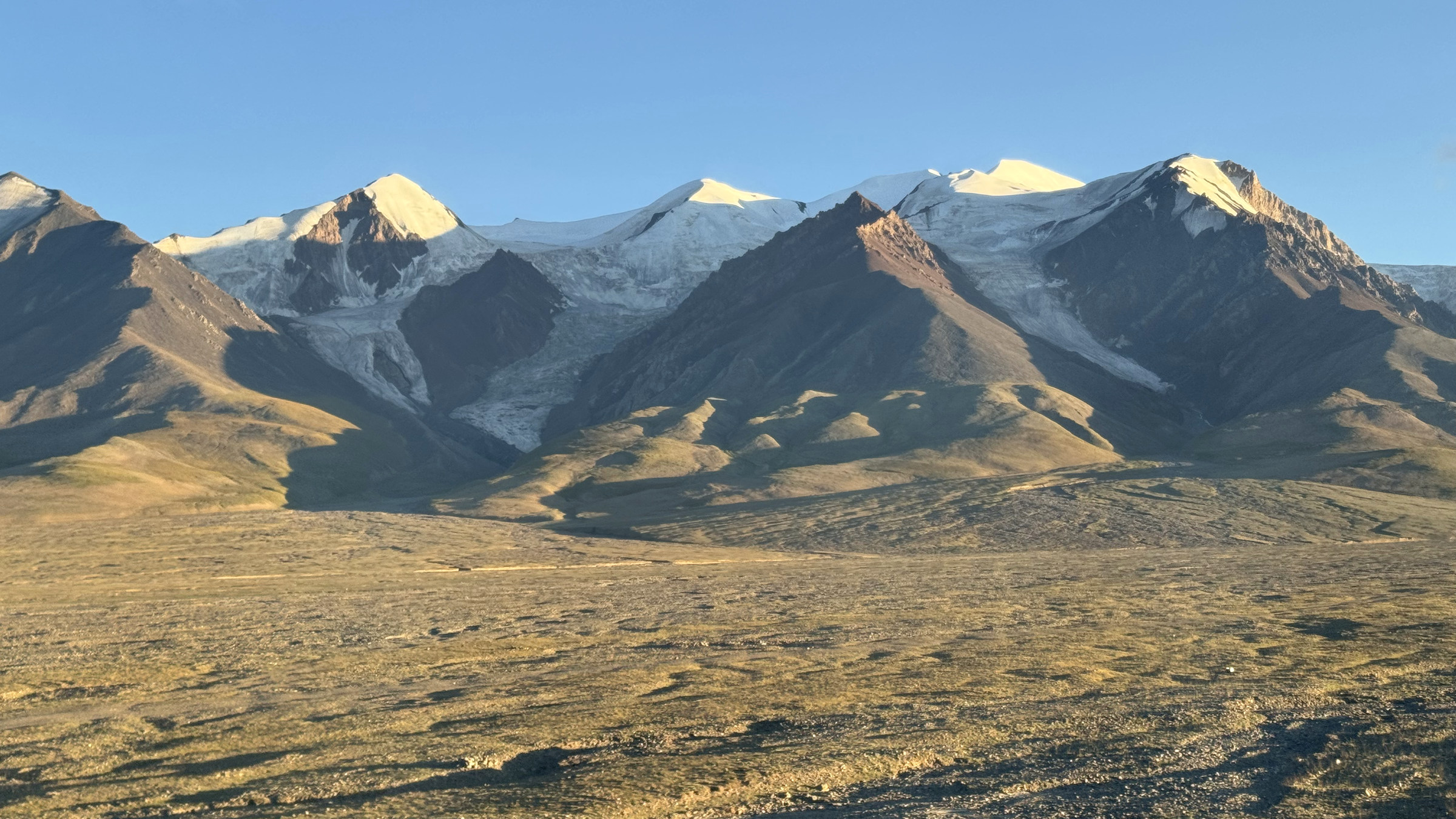 Snow mountains lit by evening light along the Qinghai–Xizang Railway