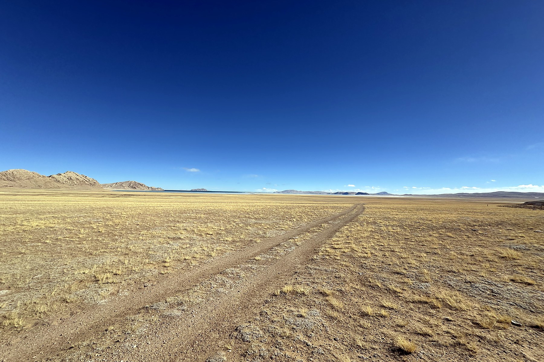Wheel tracks crossing winter grassland toward Siling Co