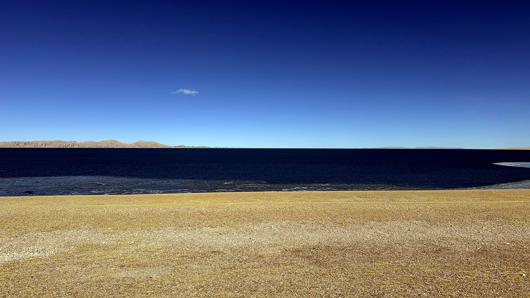 Deep blue water, a golden winter shoreline, and open sky on the western shore of Siling Co