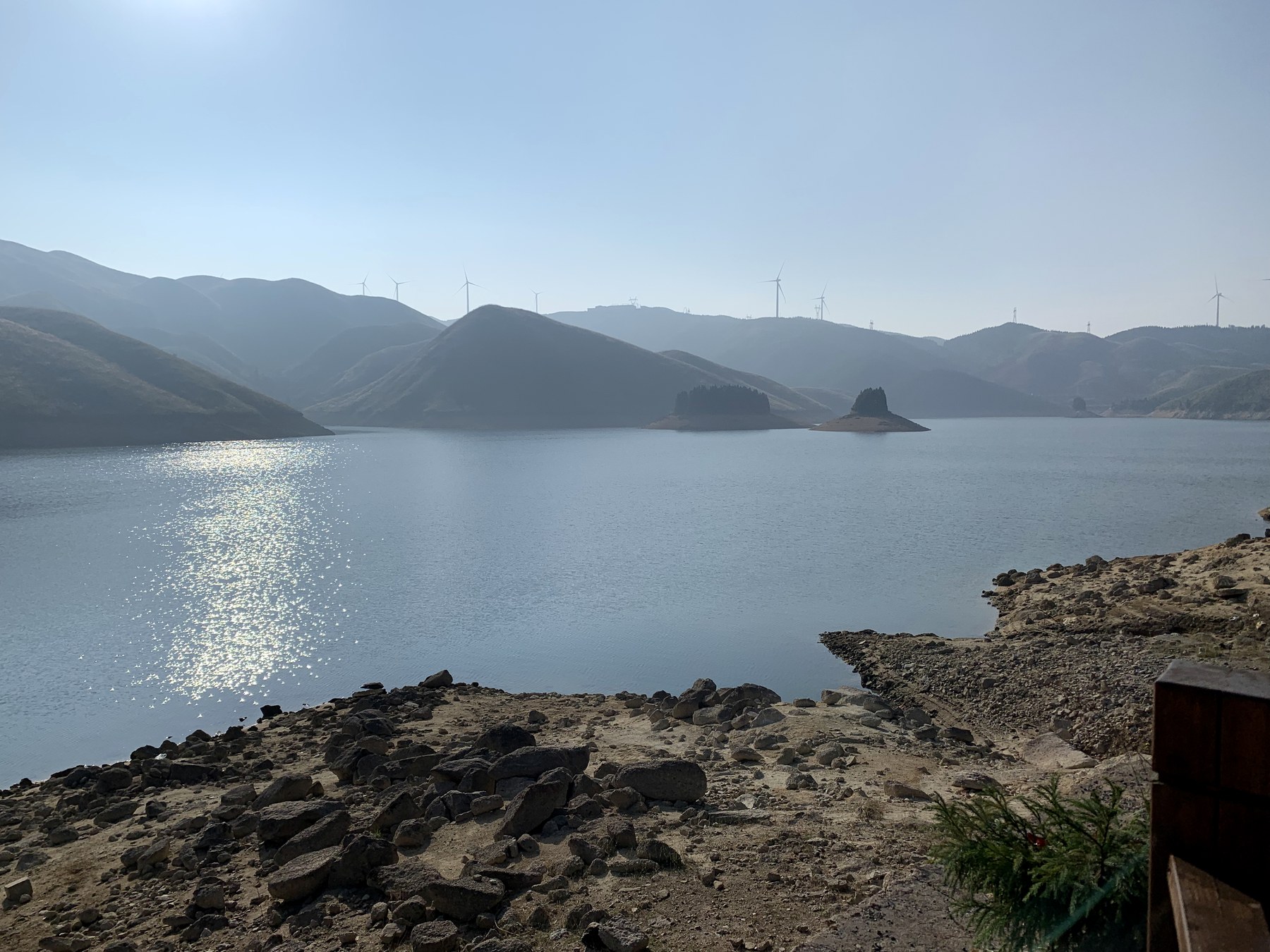 山地之间的天湖水库与远处风机
