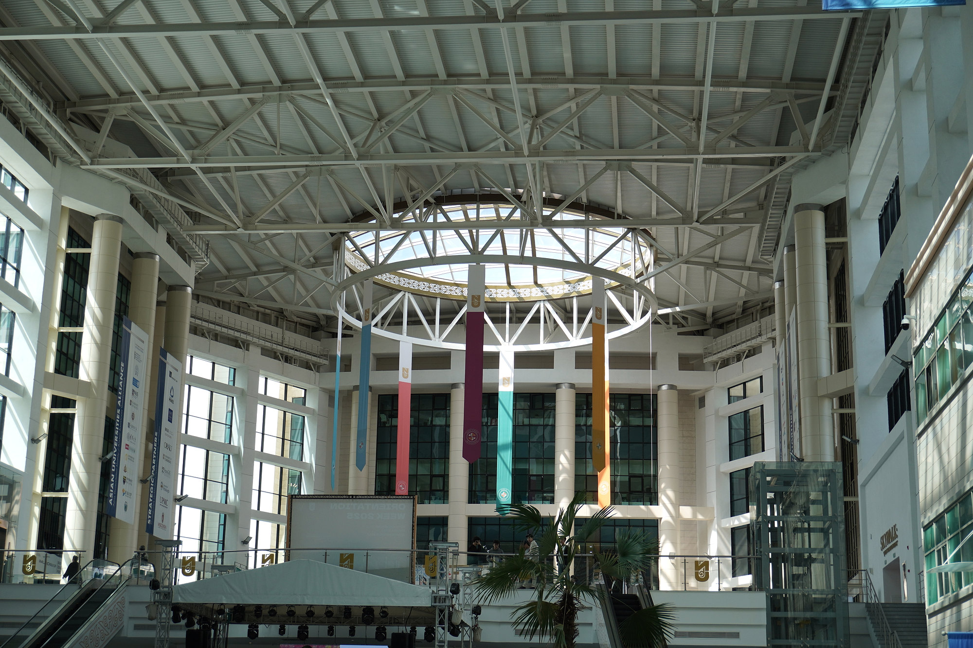 The atrium, skylight, and suspended flags inside Nazarbayev University’s School of Engineering and Digital Sciences