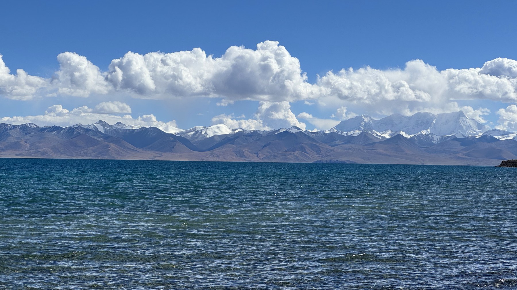 Deep-blue Namtso with snow peaks beneath clouds on the opposite shore