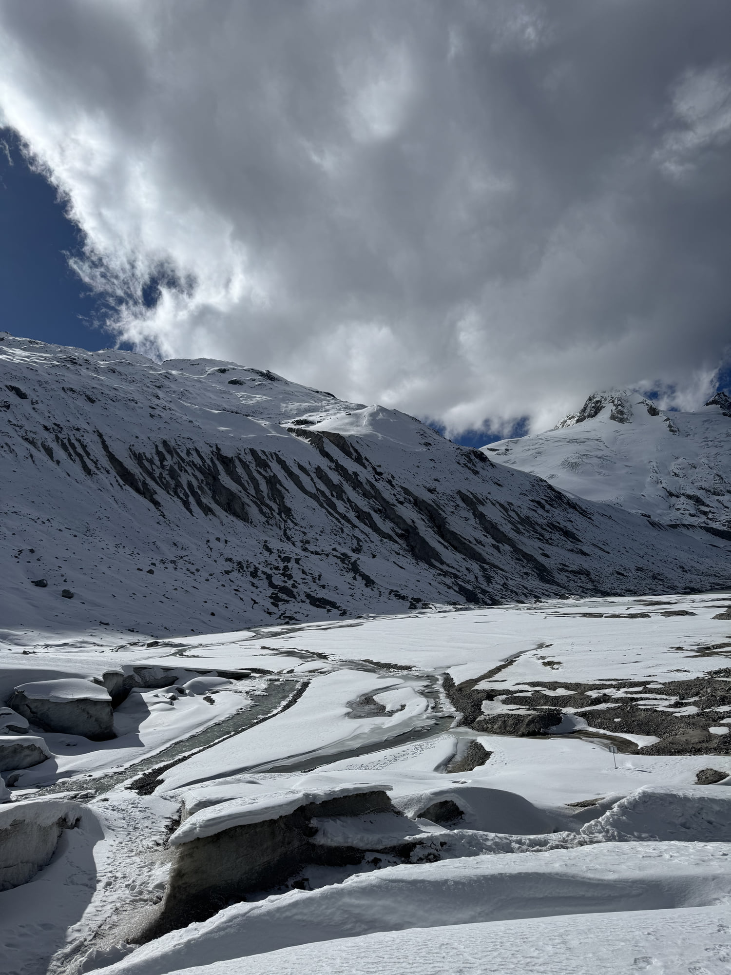 Interlaced channels in a snow-covered valley beneath an overcast sky