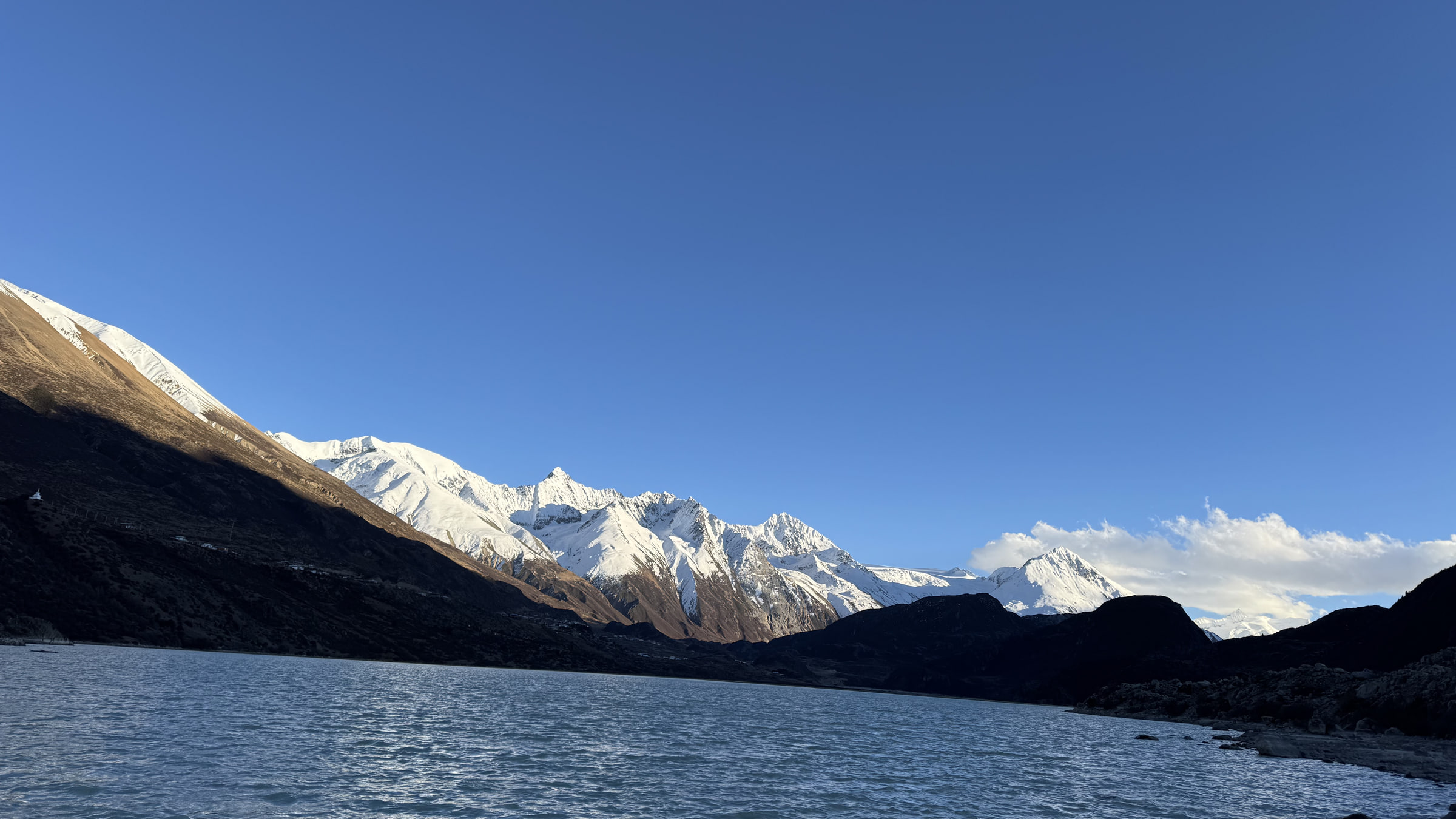 A blue lake backed by snow-covered mountains in the Ranwu Lake area